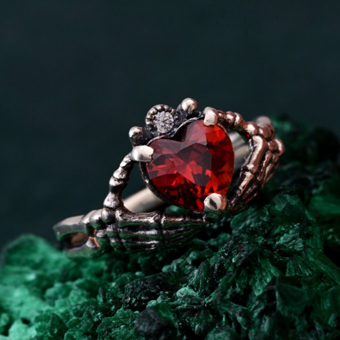 Embrace of Shadows: Gothic Skeleton Hand Garnet Ring